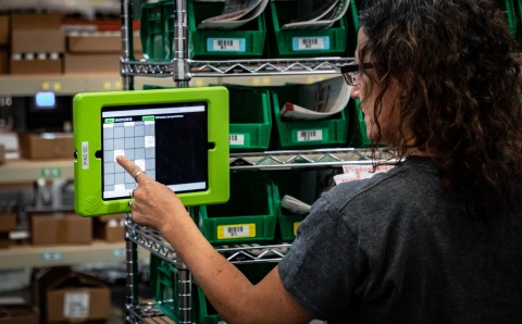 Woman operating WarehouseOS tablet